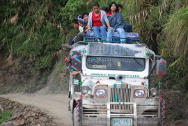 Image of a jeepney coasting along un unpaved road